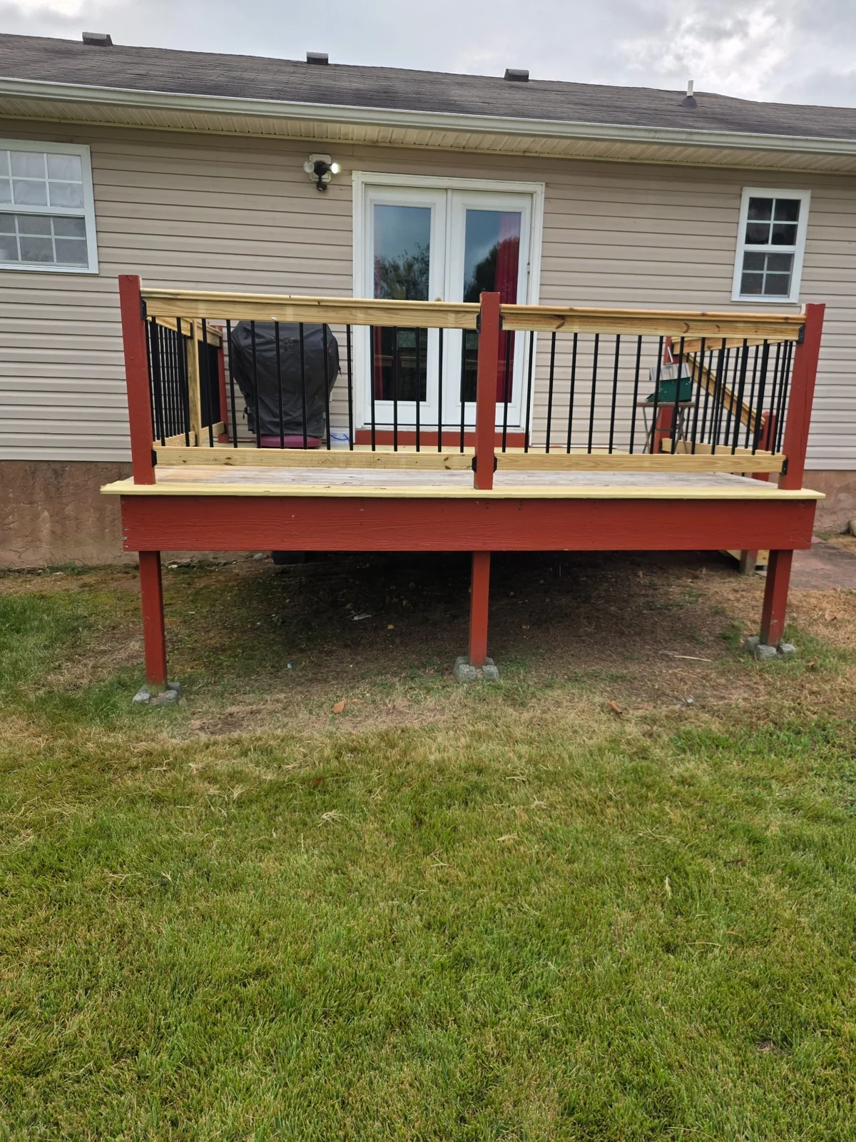 New deck boards alongside retained painted framing