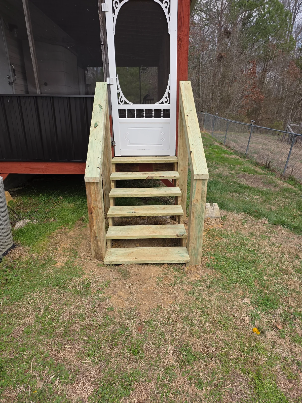 Front view of wood steps leading to a screened entry