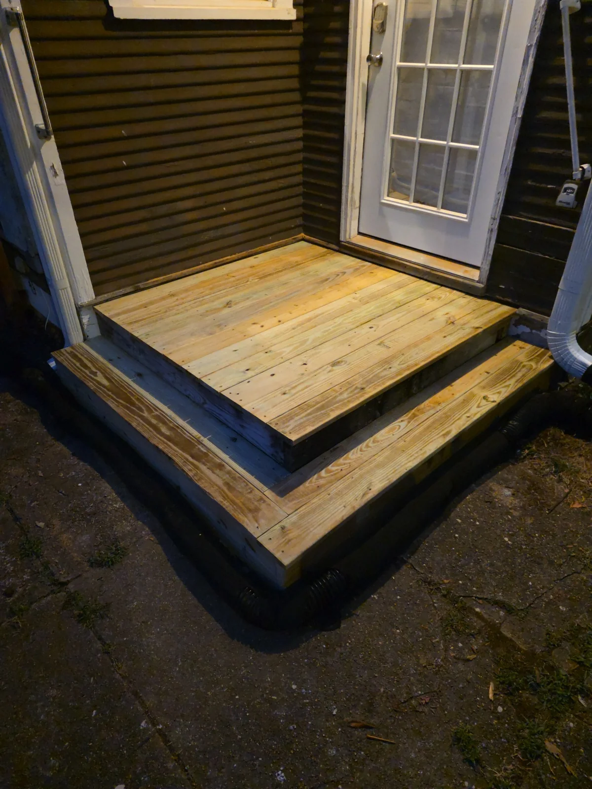 Finished wood landing and steps at an exterior entry