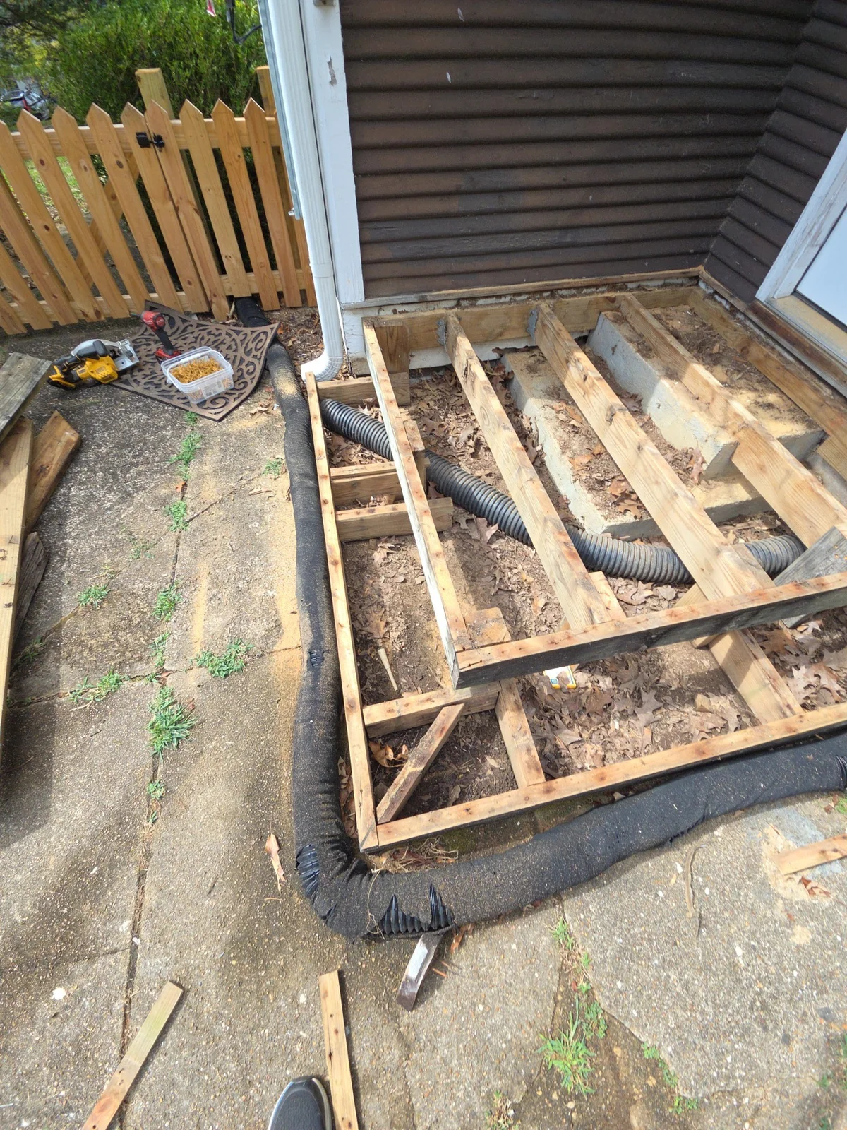 Exposed framing of the small rear landing at the exterior door with dark siding